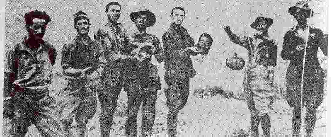 Soldados españoles sostienen trofeos de guerra